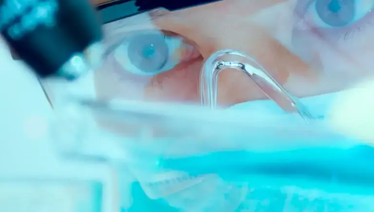 Scientist looking at petri dish on the microscope platform